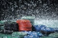 Poker playing chips on a green table and black background under the water drops. Online gambling. Royalty Free Stock Photo