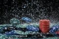 Poker playing chips on a green table and black background under the water drops. Online gambling. Royalty Free Stock Photo