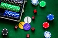 Poker set in a metallic case on a green gaming table top view