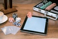 Poker set in a metallic case with tablet over wooden table, retro filtered image Royalty Free Stock Photo