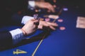 Poker table view with a pack of cards, tokens, alcohol drinks, dollar money and group of gambling rich wealthy people playing