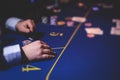 Poker table view with a pack of cards, tokens, alcohol drinks, dollar money and group of gambling rich wealthy people playing