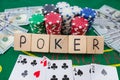 Poker text on wooden cubes with dolar poker chips and playing cards on green casino table Royalty Free Stock Photo