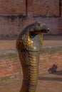 POKHARA, NEPAL - NOVEMBER 04, 2017: Close up of old rusted bronze snake statue located close to a temple in Pokhara