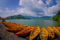 POKHARA, NEPAL - NOVEMBER 04, 2017: Close up of wooden yellow boats in a row at Begnas lake in Pokhara, Nepal, fish eye