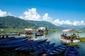 Pokhara, Nepal - October 2019: multi-colored wooden boats and catamarans near the pier on Phewa Feva Lake Royalty Free Stock Photo