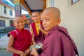 POKHARA, NEPAL - OCTOBER 06 2017: Unidentified Buddhist monk teenager holding in his hand a metallic bowl with soup and