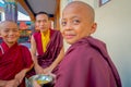 POKHARA, NEPAL - OCTOBER 06 2017: Unidentified Buddhist monk teenager holding in his hand a metallic bowl with soup and