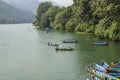 People in multicolored wooden boats on the lake against the backdrop of the green jungle Royalty Free Stock Photo