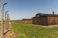 Poland Auschwitz-Birkenau 19-September 2018 View of the brown wooden barracks and the electricity fence in the Birkenau nazikamp