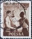 POLAND-CIRCA 1955 : A post stamp printed in Poland showing athletes shaking hands. International Youth - Sport Festival