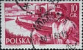 POLAND-CIRCA 1956 : A post stamp printed in Poland showing a portrait of a sailor in port with tugs and barges