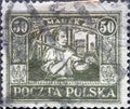 POLAND-CIRCA 1922 : A post stamp printed in Poland showing a worker with a pickaxe in front of chimneys and industrial buildings.U