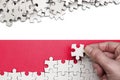 Poland flag is depicted on a table on which the human hand folds a puzzle of white color Royalty Free Stock Photo