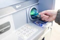 a retired woman near an ATM holds a master card bank card in her hands to withdraw money