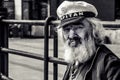Old man, sailor, with a thick beard and a captain`s cap observing ships on the quay. Poland, Gdansk