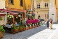 Poland, Krakow, 10 May 2019 - Tiny local cafe in center of Krakow, flowers decorating it, cobbled streets full of people