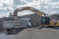 Poland Ostrowiec Swietokrzyski October 6, 2023 at 11:47. Caterpillar excavator loads gravel onto a dump truck.