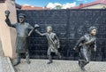 Modern art bronze statues of young schoolkids and janitor, Pultusk in Poland