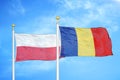 Poland and Romania two flags on flagpoles and blue cloudy sky
