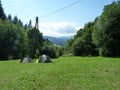 Poland, Rudawy Janowickie - the tents on the glade and Karkonosze mountain in distance.