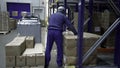 Poland, Warsaw- September 14, 2022: Worker distributes goods in warehouse. Creative. Man drags boxes in warehouse