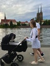 Poland, Wroclaw, 23 July, summe. A young family is walking while relaxing with a child in a stroller along the river