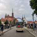 Poland, Wroclaw, July 23, summer. People and tourists pass through the bridge, a car carrying tourists