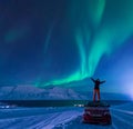 The polar arctic man Northern lights aurora borealis sky star in Norway Svalbard in Longyearbyen city moon mountains Royalty Free Stock Photo