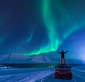 The polar arctic man Northern lights aurora borealis sky star in Norway Svalbard in Longyearbyen city moon mountains Royalty Free Stock Photo