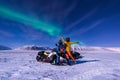 The polar arctic snowmobile Northern lights aurora borealis sky star in Norway Svalbard in Longyearbyen city man mountains