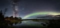 Polar Aurora lights in the starry sky over the lake in the  forest in Lapland, Finland Royalty Free Stock Photo