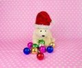 Polar bear doll wearing a Santa hat with Christmas balls.