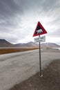 Polar bear warning sign with bikes next to it near Longyearbyen - the most Northern settlement in the world. Svalbard, Norway