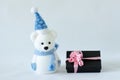 Polar bear wearing a hat and a blue scarf posed next to gifts with shiny knots on a Christmas holiday decor Royalty Free Stock Photo