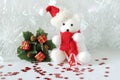 Polar bear wearing a hat and a red scarf posed next to gifts with shiny knots on a Christmas holiday decor Royalty Free Stock Photo