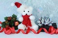 Polar bear wearing a hat and a red scarf posed next to gifts with shiny knots on a Christmas holiday decor