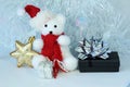 Polar bear wearing a hat and a red scarf posed next to gifts with shiny knots on a Christmas holiday decor Royalty Free Stock Photo