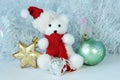 Polar bear wearing a hat and a red scarf posed next to gifts with shiny knots on a Christmas holiday decor Royalty Free Stock Photo