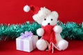 Polar bear wearing a hat and a red scarf posed next to gifts with shiny knots on a Christmas holiday decor Royalty Free Stock Photo