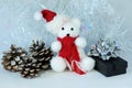 Polar bear wearing a hat and a red scarf posed next to gifts with shiny knots on a Christmas holiday decor Royalty Free Stock Photo