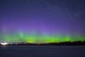 Polar northen lights aurora borealis at night in the starry sky above the lake with the island and the silhouette trees by the for Royalty Free Stock Photo