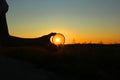 Polarizing filter in hand on sunset background