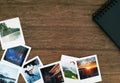 Polaroid pictures and a black spiral photo album on a wooden table with white space