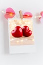 The polaroids photo red heart pinned on a lantern, white wall background