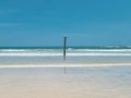 Pole on the Beach splitting the waves