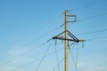 A pole with electric wires against a blue sky Royalty Free Stock Photo