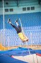 Pole vault - a female jumper falling down after the jump in the stadium Royalty Free Stock Photo