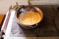 Polenta cooked in a copper cauldron on a wood stove