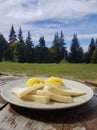 Polenta with cow cheese in a plate served in a beautiful mountains landscape.